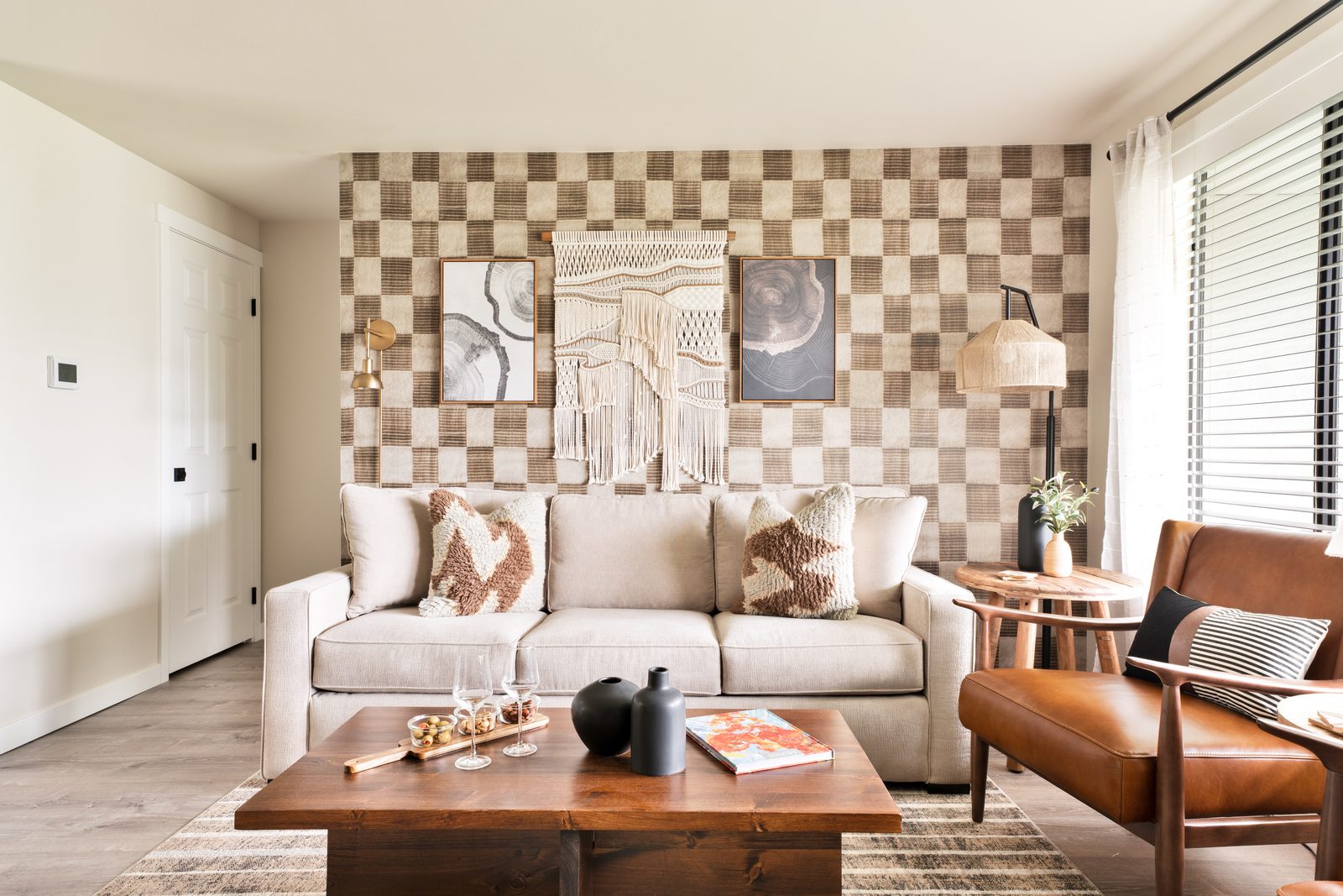 Alpine living room in Enumclaw, WA — checkerboard accent wall, neutral sofa, and macramé wall hanging